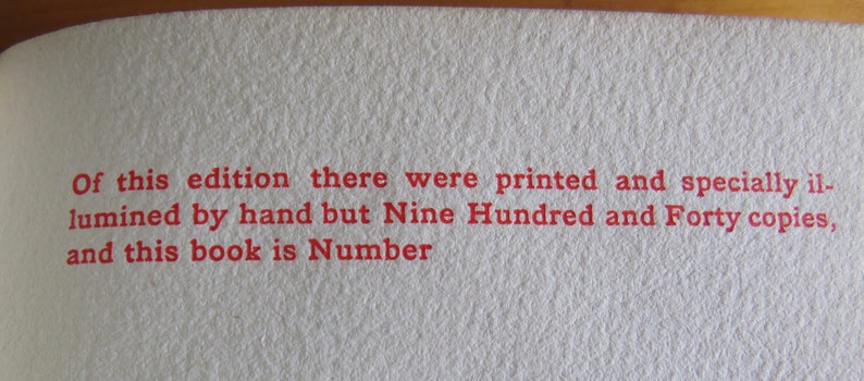 May include: Close-up of a page from a book with red text that reads "Of this edition there were printed and specially illuminated by hand but Nine Hundred and Forty copies, and this book is Number"