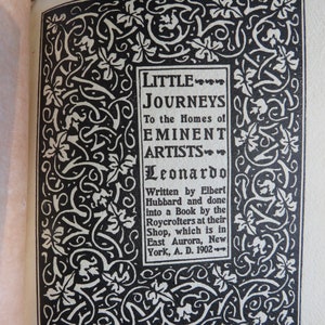 May include: A black and white illustration of a decorative border with a title card that reads "Little Journeys to the Homes of Eminent Artists - Leonardo" and text that reads "Written by Elbert Hubbard and done into a Book by the Roycrofters at their Shop, which is in East Aurora, New York, A. D. 1902."