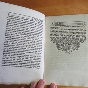May include: An open book with black and white text on a white background. The book is titled "Leonardo" and the text discusses the life of Leonardo da Vinci. The book is open to a page with a black and white illustration of a tree.