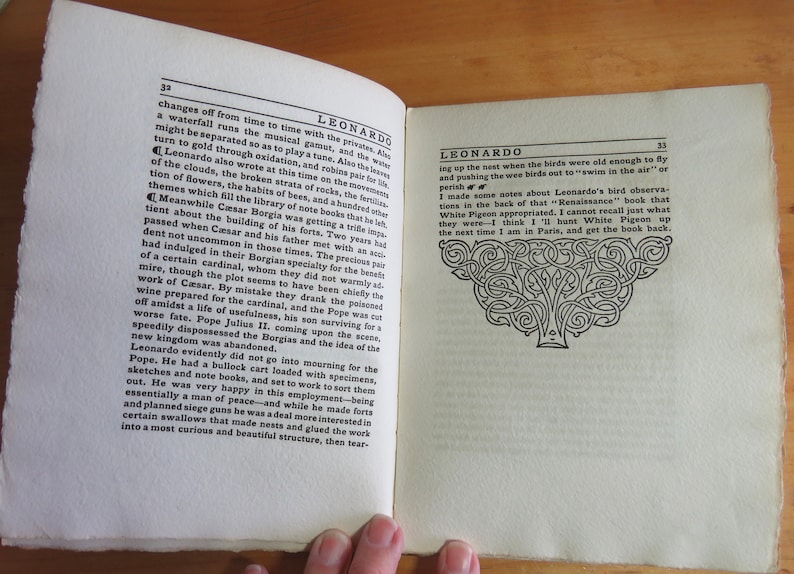 May include: An open book with black and white text on a white background. The book is titled "Leonardo" and the text discusses the life of Leonardo da Vinci. The book is open to a page with a black and white illustration of a tree.