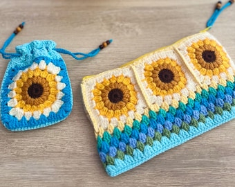 May include: A crocheted drawstring bag and a zippered pouch, both featuring sunflower designs. The bag is turquoise with a sunflower in the center, and the pouch has three sunflower squares. The items are handmade and sit on a wooden surface.