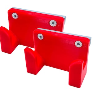May include: Two red plastic wall hooks with a silver screw in each. The hooks are designed to hold items like towels or robes.