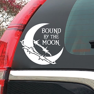 May include: A white vinyl decal applied to a car window featuring a crescent moon graphic wrapped in barbed wire. The text "BOUND BY THE MOON" is printed in a stylized serif font within the curve of the moon, creating a high-contrast design.