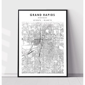 May include: Black and white map print of Grand Rapids, Michigan. The map shows the city streets and landmarks. The text "GRAND RAPIDS" and "MICHIGAN" is at the top of the map. The coordinates "42.9634°N - 85.6681°W" are below the text.