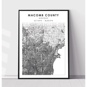 May include: Black and white map print of Macomb County, Michigan. The map shows the county's roads, streets, and waterways. The text "Macomb County, Michigan 42.7169°N - 82.8210°W" is printed at the top of the map.