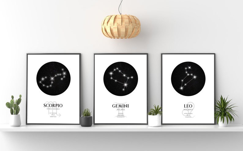 May include: Three black framed prints with white backgrounds and black circles containing white constellations. The constellations are labelled "Scorpio", "Gemini", and "Leo".