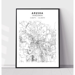 May include: A black and white line art map of Arusha, Tanzania. The map shows the city's streets and roads. The text "ARUSHA TANZANIA 3.3869°S - 36.6830°E" is printed at the top of the map.