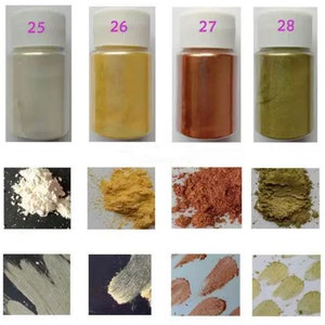 May include: Four small jars of iridescent pigment powder in white, gold, copper, and green. The jars are labeled 25, 26, 27, and 28. The powder is shown in a separate image, with a close-up of the powder and a sample of the powder applied to a surface.