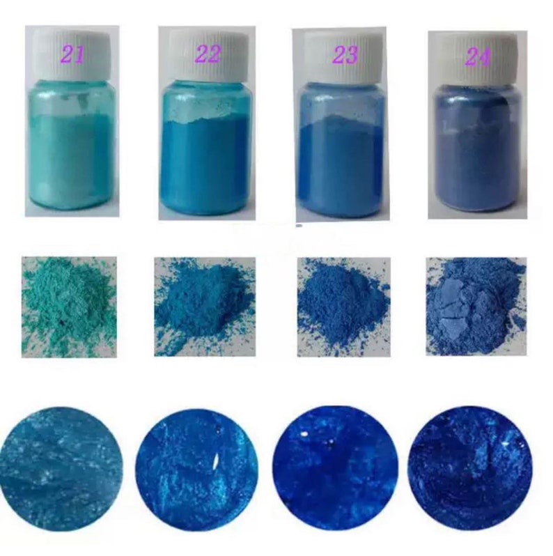 May include: Four small jars of blue and turquoise iridescent pigment powder. The jars are labeled 21, 22, 23, and 24. The powder is shown in three states: in the jar, loose, and as a thick paste.