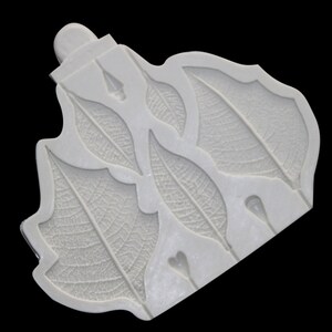 Può includere: Stampo in silicone bianco con cinque forme di foglie. Le foglie hanno motivi di venature dettagliati.