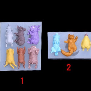 Könnte beinhalten: Zwei Silikonformen zum Backen. Die erste Form hat acht Vertiefungen in Form verschiedener Tiere, darunter ein Schwein, eine Katze, ein Hund und ein Vogel. Die zweite Form hat vier Vertiefungen in Form verschiedener Tiere, darunter eine Katze, ein Hund und ein Vogel. Die Formen sind mit 1 und 2 nummeriert.