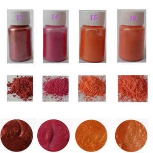 May include: Four small jars of iridescent pigment powder in shades of copper, pink, orange, and peach. The jars are labeled 13, 14, 15, and 16. Below each jar is a small pile of the powder.