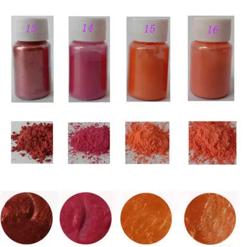 May include: Four small jars of iridescent pigment powder in shades of copper, pink, orange, and peach. The jars are labeled 13, 14, 15, and 16. Below each jar is a small pile of the powder.