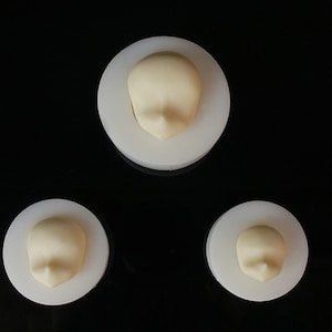 Può includere: Tre stampi in silicone bianco per realizzare teste di bambola. Gli stampi sono circolari e presentano un design in rilievo di un viso di bambola.