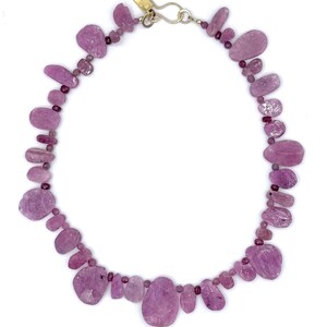 May include: A white ceramic mug with a black handle and the text "But First, Coffee" in a bold, black font. The mug is set against a neutral background, highlighting its simple design.