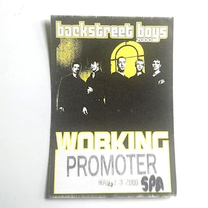 May include: A rectangular Backstreet Boys 2000 promotional pass. The pass features a black and yellow design with the band's name and a photo of the band members. The text "WORKING PROMOTER" is prominently displayed.