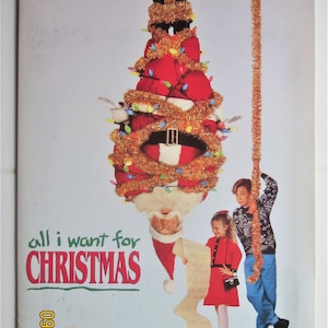 May include: A Christmas-themed image with Santa Claus upside down, tangled in Christmas lights and tinsel. Two children stand below him, one holding a long strand of tinsel and the other holding a list that reads "Mommy, Stereo, Ballet, Clothes, Bicycle, Doll, Game". The text "all i want for CHRISTMAS" is printed in red and green letters.