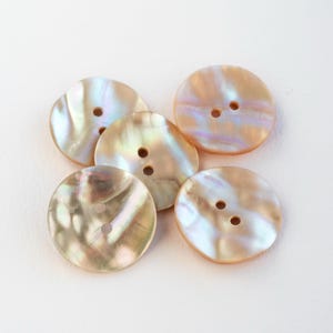 May include: A handmade ceramic mug with a speckled, cream glaze. It has a wide, rounded body and a sturdy handle. The interior is a darker, earthy tone. Ideal for tea or coffee.