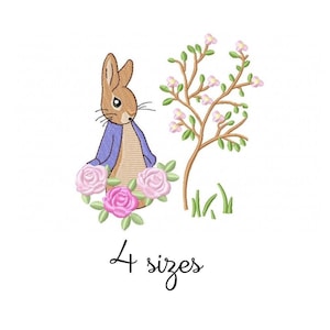 Pode incluir: Desenho bordado com Peter Rabbit com um casaco roxo, rodeado de rosas cor-de-rosa, de pé ao lado de um pequeno arbusto verde com flores cor-de-rosa. O texto "4 tamanhos" está abaixo da imagem.
