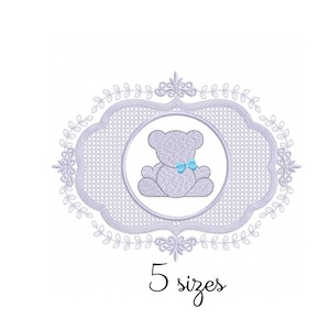 Pode incluir: Um desenho bordado de cor lilás claro que representa um urso de peluche com uma gravata borboleta azul dentro de uma moldura decorativa com uma borda floral. O texto "5 tamanhos" está abaixo da moldura.