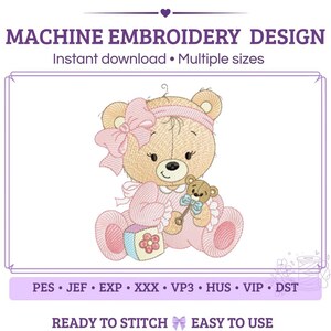 Pode incluir: Um design de bordado à máquina com um urso de peluche castanho claro a usar uma fita cor-de-rosa com um laço grande e um conjunto às riscas cor-de-rosa. O urso segura um pequeno guizo de urso e está sentado ao lado de um bloco colorido com flores.