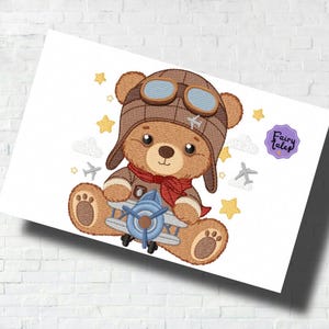 May include: A brown teddy bear wearing a brown aviator hat with goggles and a red scarf, holding a blue and gray toy airplane. The bear is surrounded by white clouds and yellow stars.