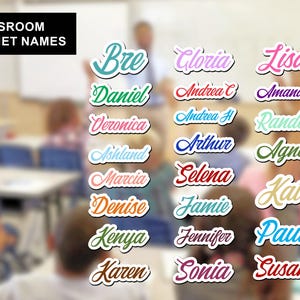 May include: A collection of classroom magnet names featuring various first names written in a cursive script font. Each name is displayed in a different solid color with a white outline, including Bre, Daniel, Veronica, Ashland, Marcia, Denise, Kenya, Karen, Gloria, Andrea C, Andrea H, Arthur, Selena, Jamie, Jennifer, Sonia, Lisa, Amanda, Randee, Agnes, Kat, Paul, and Susan.