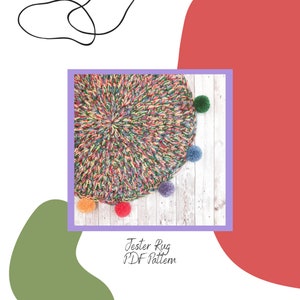 Puede incluir: Una alfombra de crochet colorida con un diseño circular y pompones alrededor del borde. La alfombra está sobre una superficie de madera blanca. "Jester Rug PDF Pattern" está escrito debajo de la alfombra.