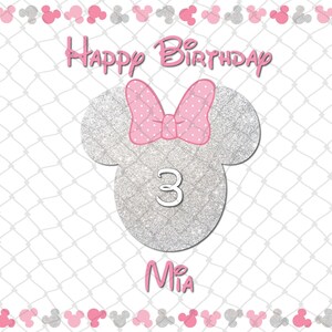 Peut inclure: Une carte d'anniversaire avec une silhouette de Minnie Mouse en paillettes argent&eacute;es, un n&oelig;ud rose &agrave; pois, le chiffre "3" et le nom "Mia". Les mots "Happy Birthday" sont &eacute;crits en haut.