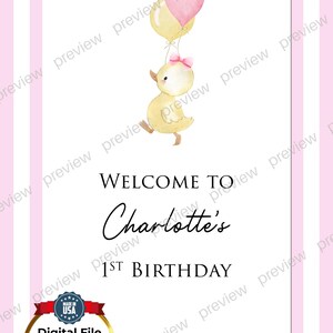 Puede incluir: Un letrero de cumplea&ntilde;os a rayas rosas y blancas con una ilustraci&oacute;n de un patito amarillo con globos. El letrero dice "Bienvenida al 1er cumplea&ntilde;os de Charlotte". Incluye un sello "Made in USA".