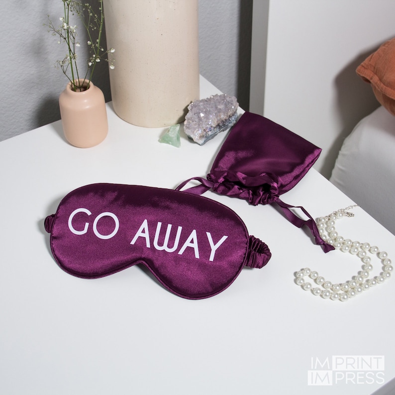 May include: Purple satin sleep mask with white text that reads "GO AWAY".