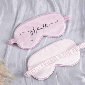 May include: Two pink satin sleep masks. One mask has the name "gracie" written in black cursive script.
