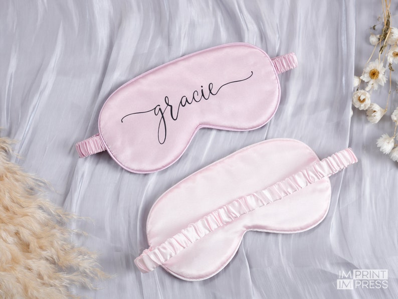 May include: Two pink satin sleep masks. One mask has the name "gracie" written in black cursive script.