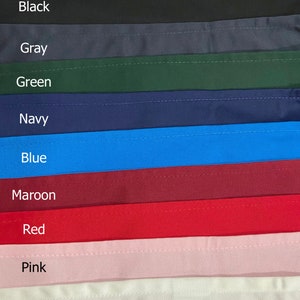 May include: A close-up of fabric swatches in various colors, including black, gray, green, navy, blue, maroon, red, pink, and white. The swatches are arranged in a vertical stack, with the darkest color at the top and the lightest color at the bottom.