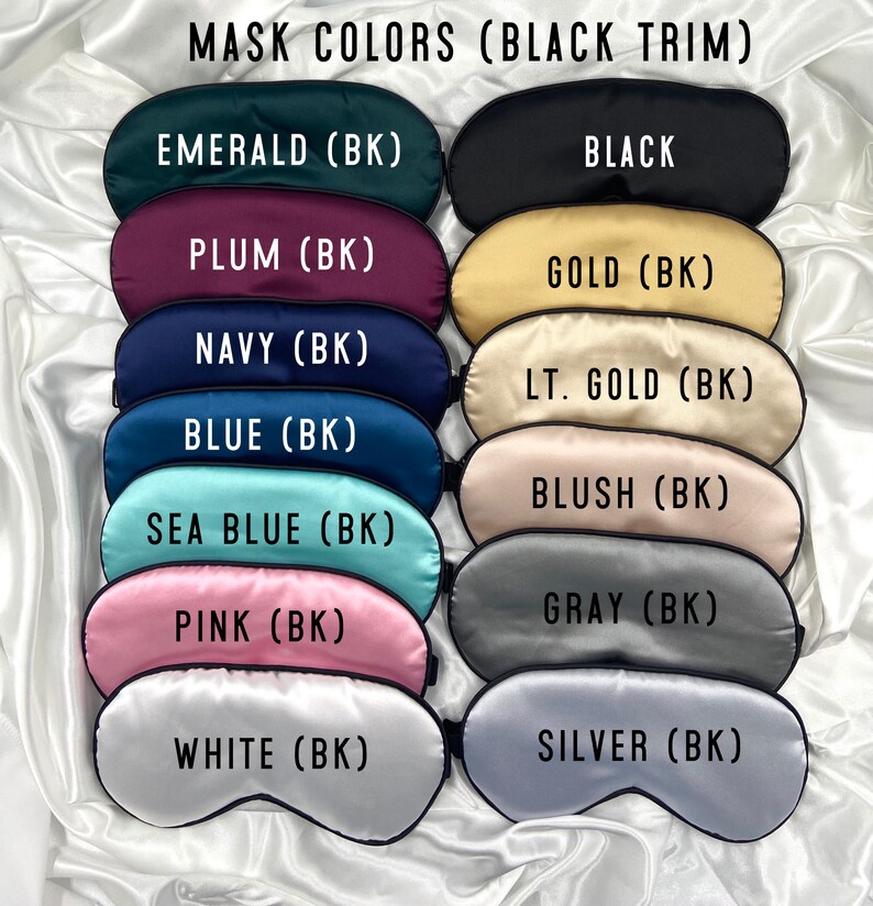 May include: A set of 12 sleep masks in various colors with black trim. The colors include emerald, black, plum, gold, navy, light gold, blue, blush, sea blue, gray, pink, white, and silver. Each mask has the color name and (BK) printed on it.
