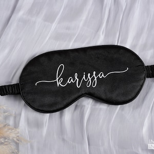 May include: Black satin sleep mask with the name "karissa" written in white cursive script.
