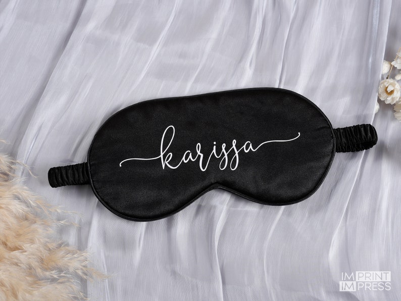 May include: Black satin sleep mask with the name "karissa" written in white cursive script.