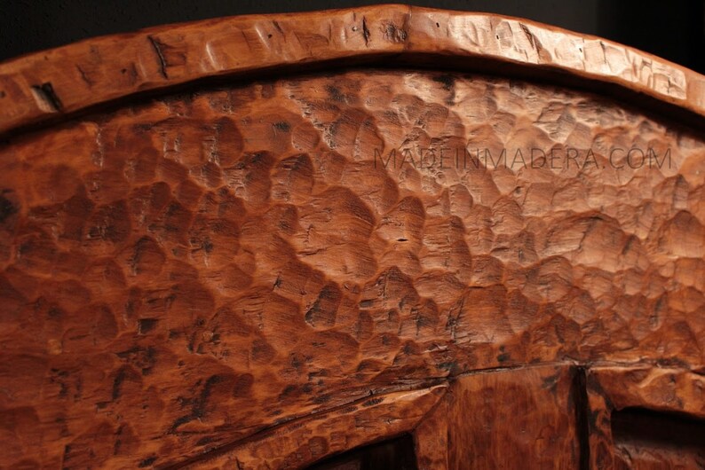 Puede incluir: Primer plano de un cuenco de madera con una superficie rugosa y texturizada. El cuenco est&aacute; hecho de madera marr&oacute;n oscura y tiene una forma redondeada.