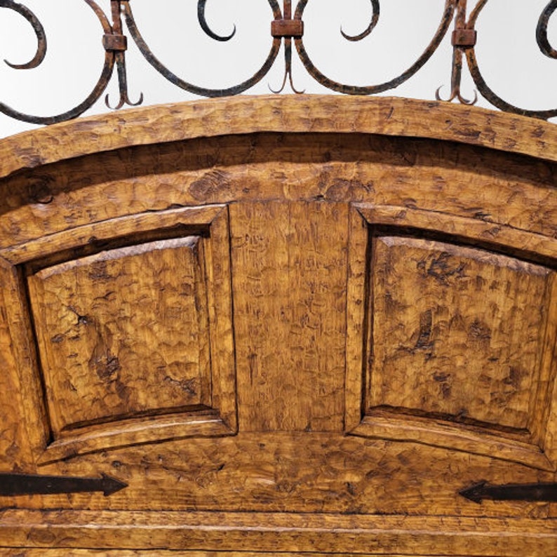 May include: A wooden headboard with a curved top and a wrought iron design. The headboard has a distressed finish and is made of solid wood.