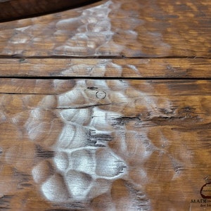 May include: Close-up of a wooden surface with a light brown stain. The wood has a natural, rustic look with knots and grain patterns. The surface is smooth and polished.
