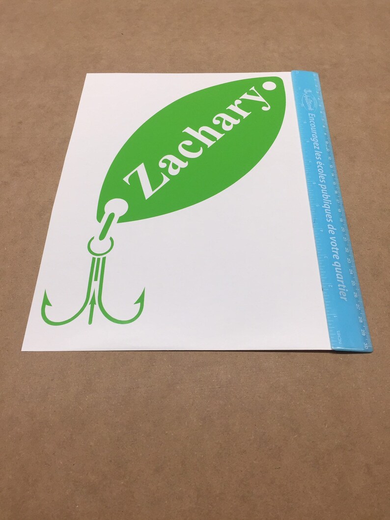 May include: Green and white vinyl decal of a fishing lure with the name Zachary on the lure.