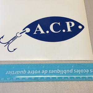 May include: A blue and white decal of a fishing lure with the text "A.C.P." on the lure.