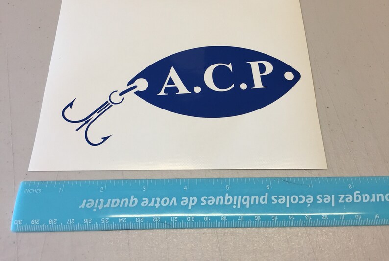 May include: A blue and white decal of a fishing lure with the text "A.C.P." on the lure.