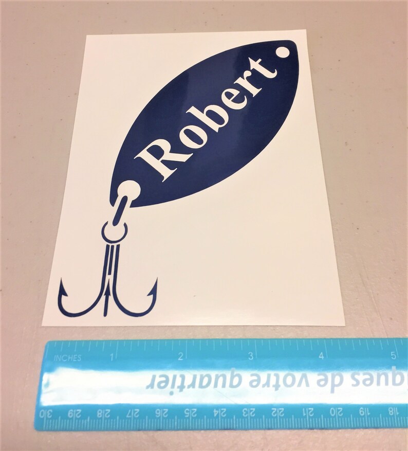 May include: A blue and white vinyl decal of a fishing lure with the name "Robert" on it. The decal is approximately 4 inches long.