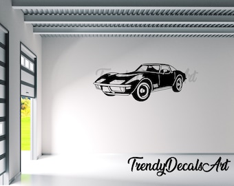 May include: Black silhouette of a classic sports car on a white wall. The car is a vintage model with a low profile and rounded features. The text "Trendy Decals Art" is below the car.