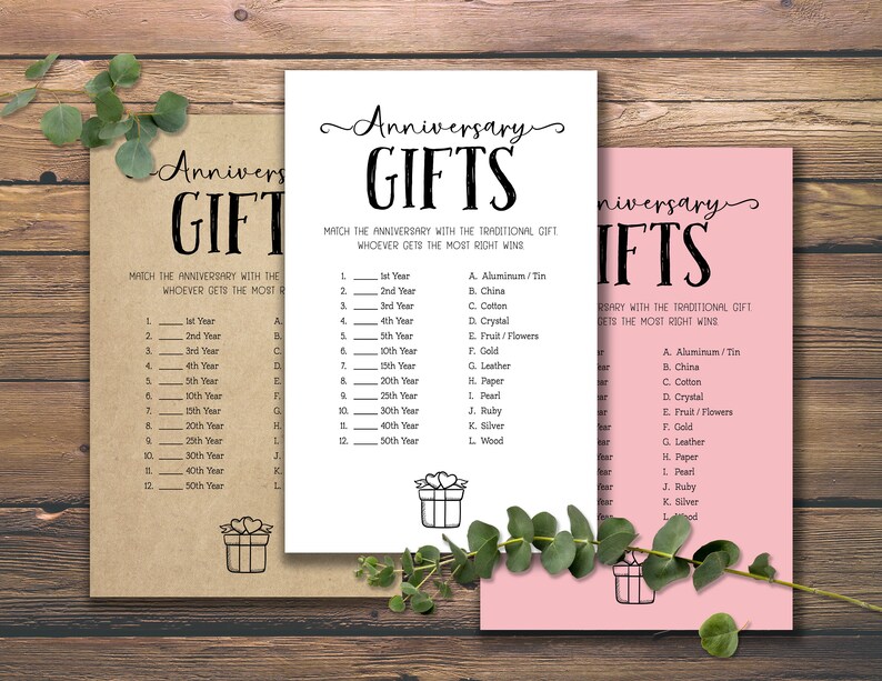 Puede incluir: Tres tarjetas de juego imprimibles con el t&iacute;tulo "Anniversary Gifts". Cada tarjeta tiene una lista de regalos tradicionales de aniversario, como papel, plata y oro, emparejados con el a&ntilde;o correspondiente. Las tarjetas est&aacute;n impresas en papel marr&oacute;n, blanco y rosa.