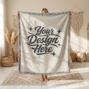 May include: A beige woven throw blanket with a decorative fringe. The blanket features the text "Your Design Here" in a dark gray script. The fringe has a mix of colors.