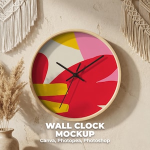 May include: A round wall clock with a light wood frame. The clock face features an abstract design with red, yellow, pink, and white shapes. Black clock hands indicate the time. The text "WALL CLOCK MOCKUP" is at the bottom.