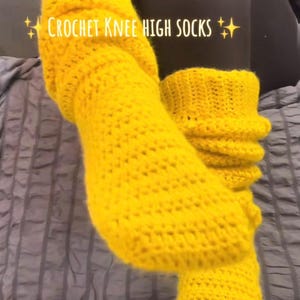 Peut inclure: Chaussettes hautes au genou en crochet jaune vif. Les chaussettes sont faites à la main avec un point texturé et comportent le texte "CROCHET KNEE HIGH SOCKS". Les chaussettes sont d'une couleur vive et unie.
