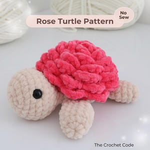 Könnte beinhalten: Gehäkelte Schildkröte mit rosenförmigem Panzer in leuchtendem Pink. Der Kopf, die Füße und der Körper sind beige, mit einem schwarzen Auge. Der Text "Rose Turtle Pattern" ist sichtbar. Ein Bastelprojekt.